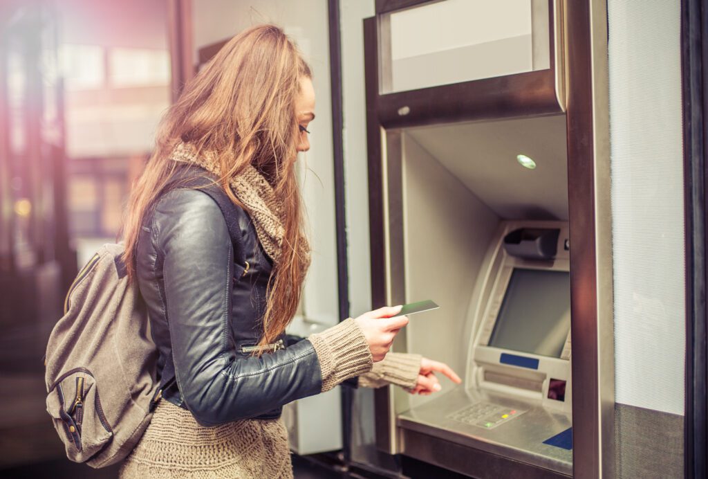 young woman using ATM